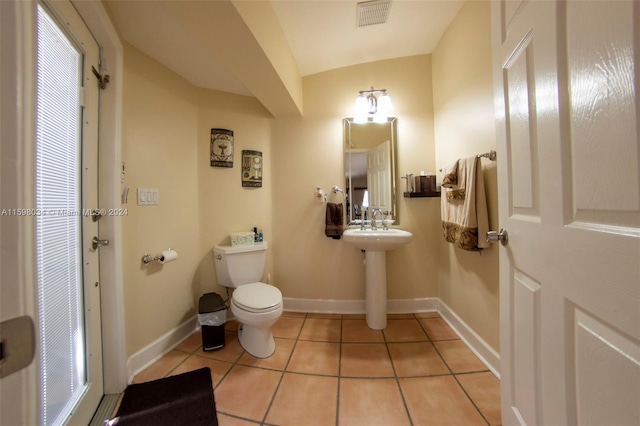 bathroom with tile patterned flooring, vaulted ceiling, and toilet