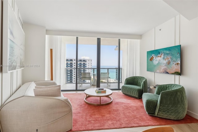 living room featuring floor to ceiling windows, a water view, and hardwood / wood-style flooring