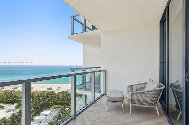 balcony featuring a beach view and a water view