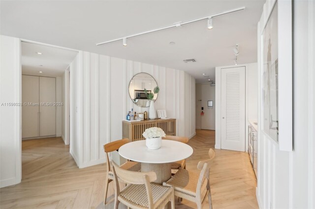 dining room featuring rail lighting and light parquet floors