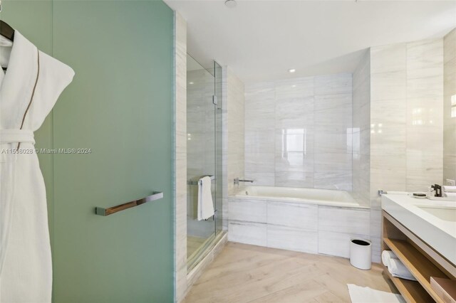 bathroom featuring vanity, tile walls, and plus walk in shower