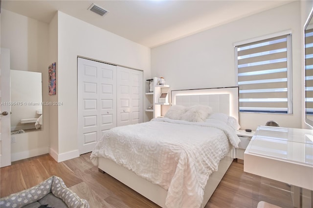 bedroom with a closet and hardwood / wood-style floors