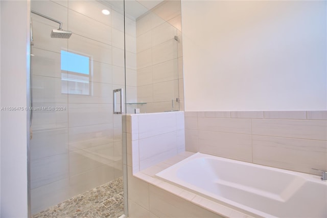 bathroom featuring shower with separate bathtub