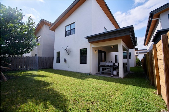 rear view of house featuring a patio and a lawn