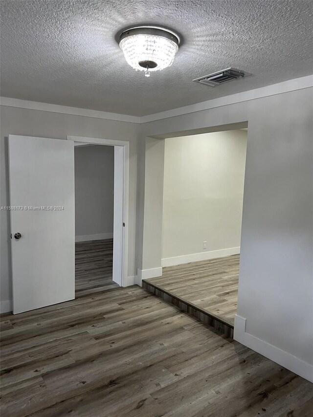 empty room featuring a textured ceiling and hardwood / wood-style flooring