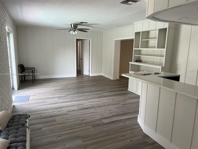 unfurnished living room featuring ceiling fan and dark wood-type flooring