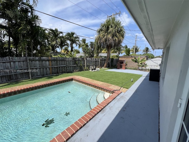 view of pool with a lawn