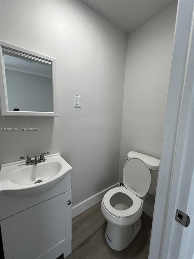 bathroom featuring toilet, vanity, and hardwood / wood-style flooring