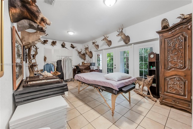 bedroom featuring light tile floors, french doors, and access to outside