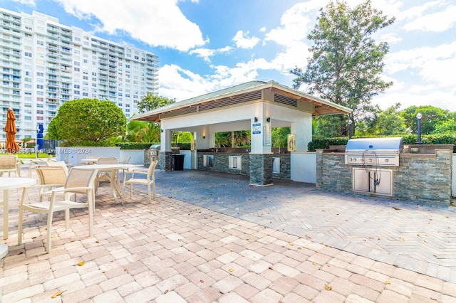 view of patio with an outdoor kitchen and a grill