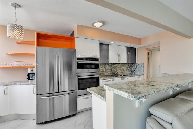 kitchen with a kitchen breakfast bar, tasteful backsplash, decorative light fixtures, white cabinets, and appliances with stainless steel finishes