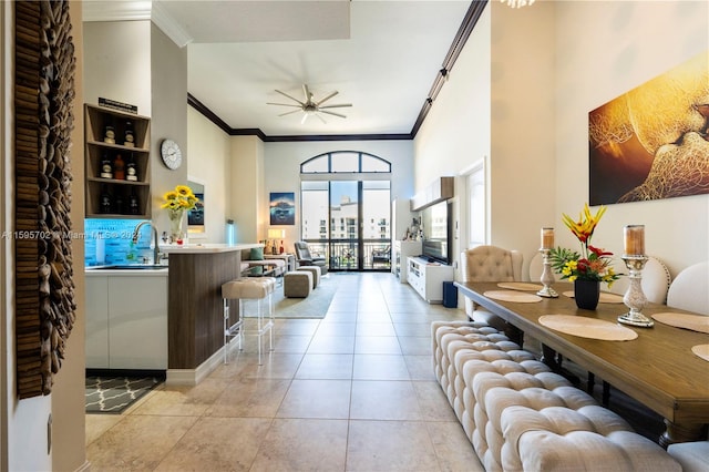 tiled living room with sink, ornamental molding, and ceiling fan