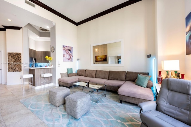 tiled living room with a towering ceiling and ornamental molding