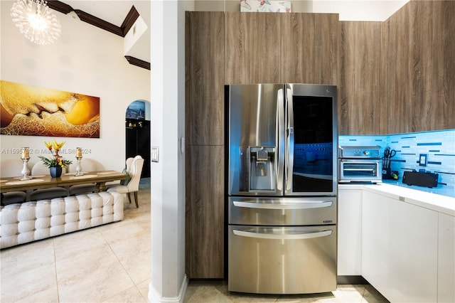 kitchen featuring white cabinets, stainless steel fridge, tasteful backsplash, and light tile floors