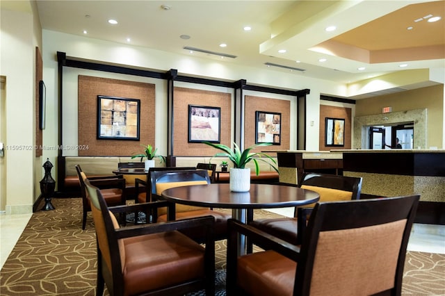 tiled dining space with a barn door and a raised ceiling