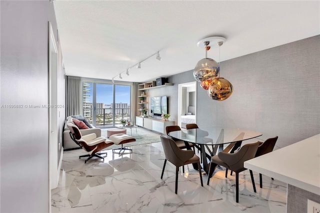 dining space featuring floor to ceiling windows, track lighting, and light tile floors