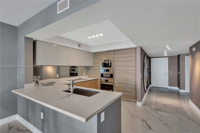 kitchen with gray cabinetry, sink, light tile flooring, and kitchen peninsula