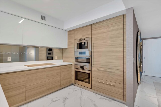 kitchen featuring stainless steel double oven, light tile flooring, and black electric cooktop