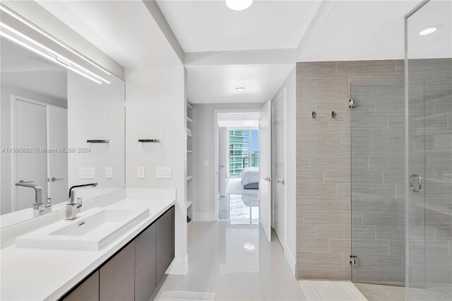 bathroom featuring tile floors, a shower with door, and large vanity