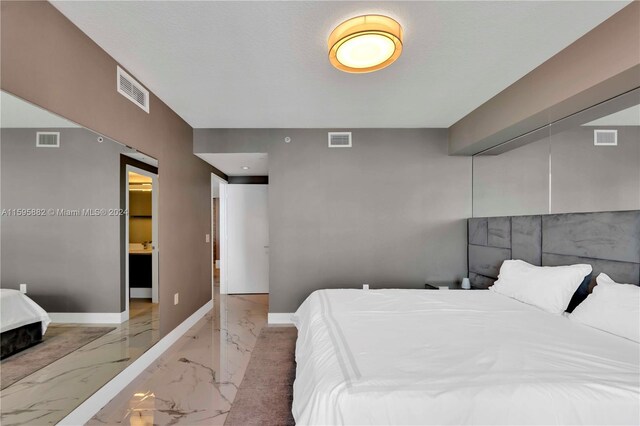 bedroom featuring tile floors, a closet, and connected bathroom