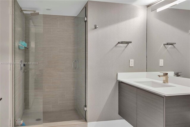 bathroom featuring vanity with extensive cabinet space and walk in shower