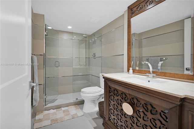 bathroom with an enclosed shower, vanity, and toilet