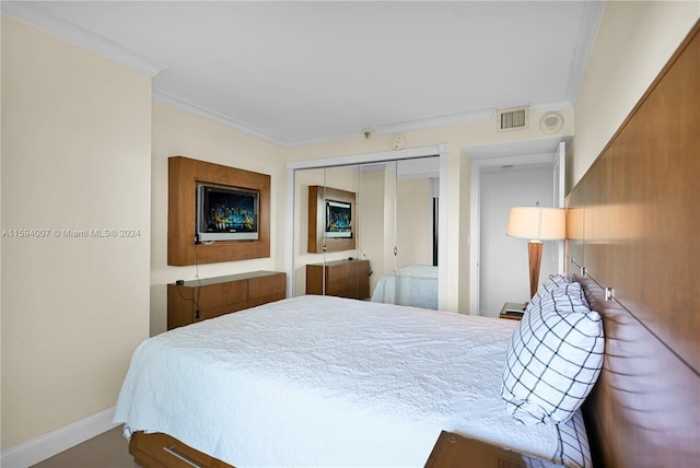 bedroom featuring crown molding and a closet