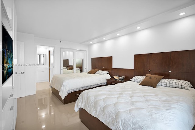 bedroom with light tile patterned flooring and connected bathroom