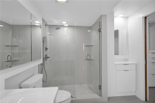 bathroom featuring an enclosed shower, vanity, and toilet