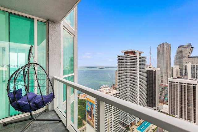 balcony featuring a water view and central air condition unit