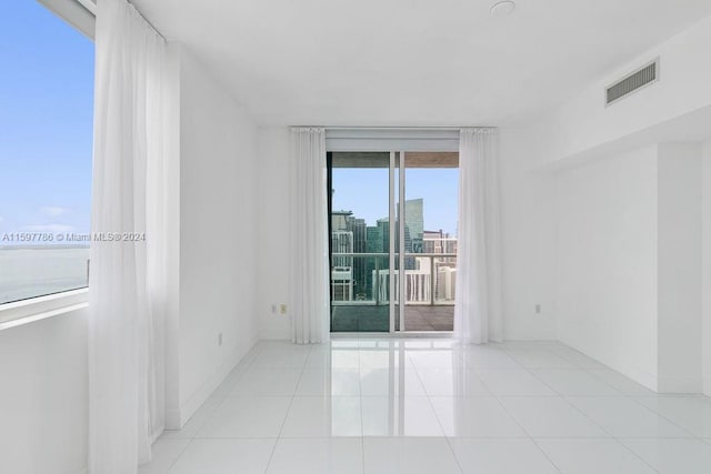 empty room with baseboards, visible vents, and tile patterned floors