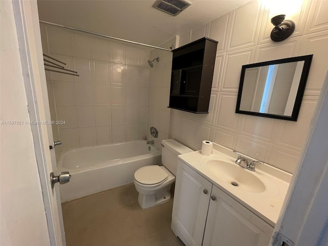 full bathroom featuring vanity, tile patterned flooring, tiled shower / bath combo, toilet, and tile walls