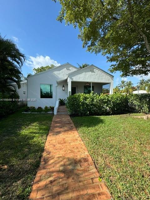 view of front of house with a front lawn and stucco siding