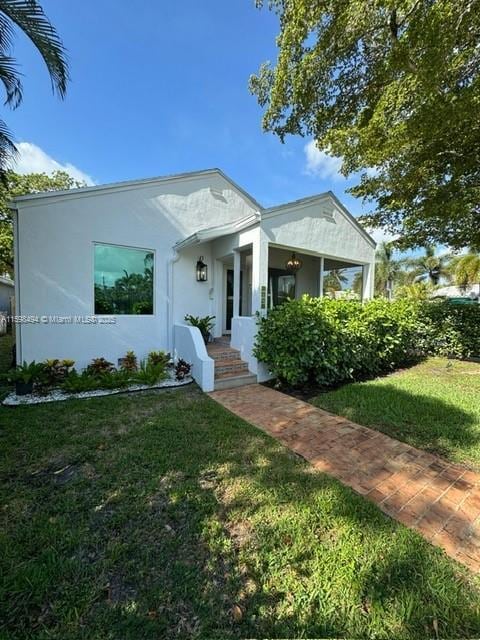 view of front facade with a front lawn and stucco siding