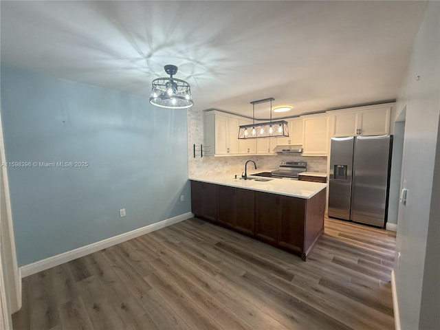 kitchen with dark hardwood / wood-style floors, white cabinetry, backsplash, kitchen peninsula, and stainless steel appliances