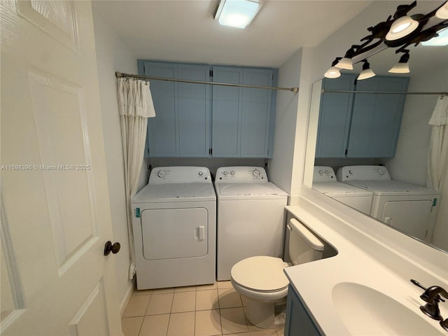 bathroom featuring vanity, washing machine and clothes dryer, tile patterned floors, and toilet