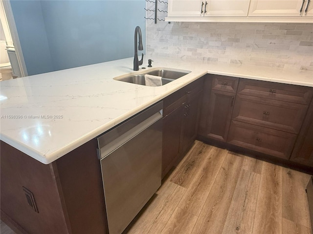 kitchen with sink, white cabinetry, light wood-type flooring, dishwasher, and decorative backsplash