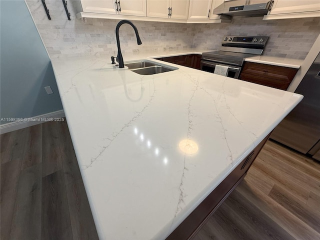 kitchen with light stone countertops, sink, white cabinets, and stainless steel electric range