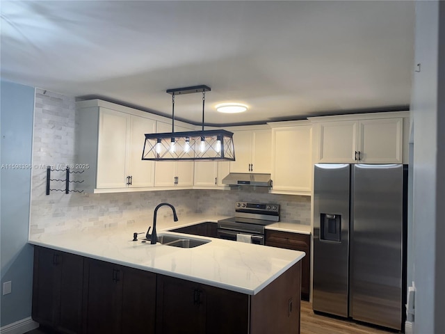 kitchen with sink, decorative light fixtures, white cabinets, stainless steel appliances, and backsplash