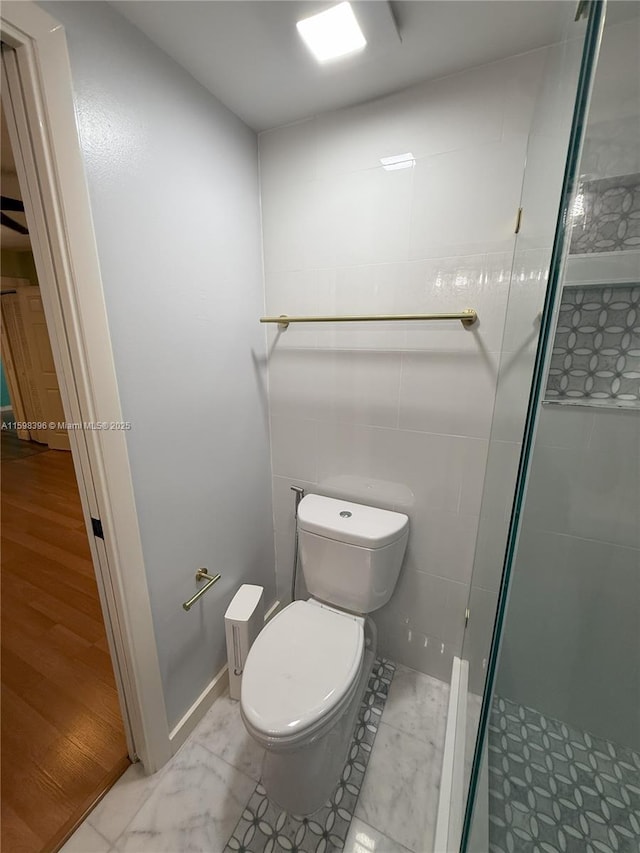 bathroom featuring tile walls, toilet, and walk in shower