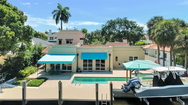 back of house featuring a fenced in pool and a patio