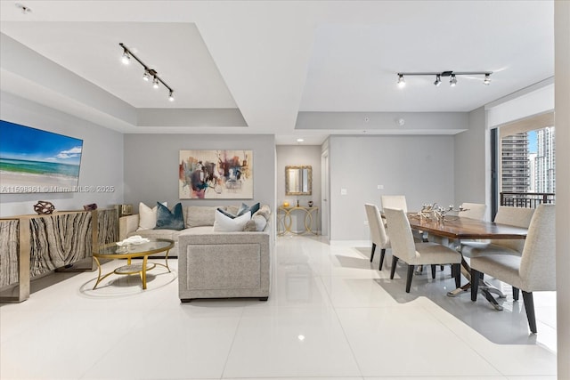 living room with light tile patterned flooring and a tray ceiling