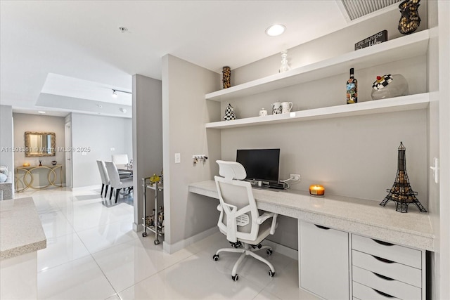 office area with light tile patterned floors and built in desk