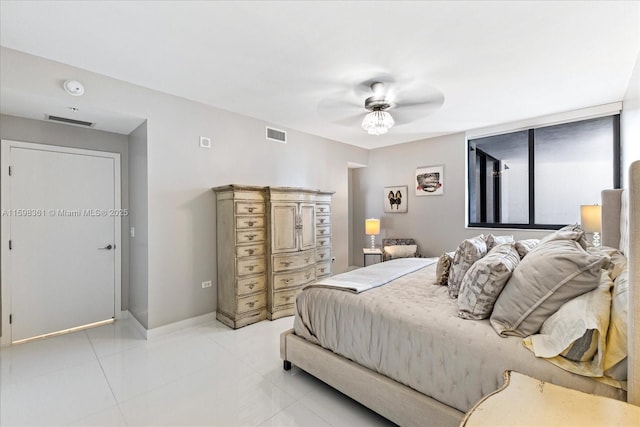 bedroom featuring ceiling fan, light tile patterned floors, and a wall of windows