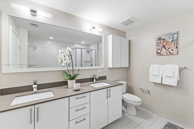 bathroom featuring vanity, toilet, tile patterned flooring, and walk in shower