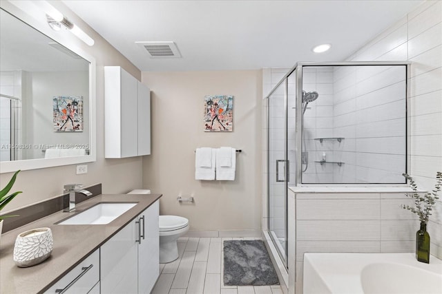 full bathroom featuring toilet, shower with separate bathtub, and vanity