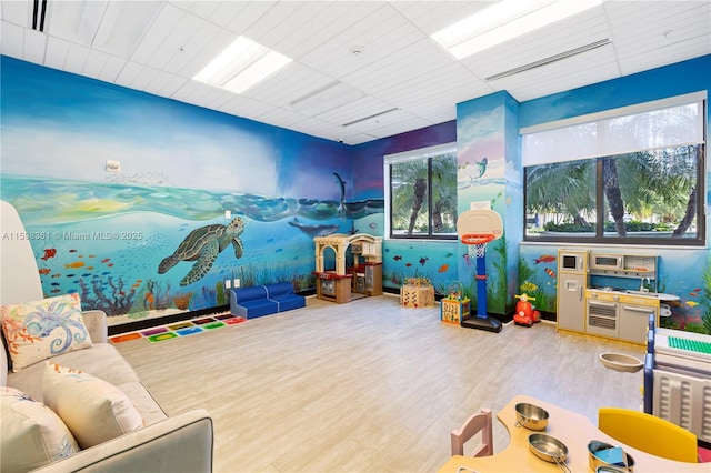 playroom featuring a drop ceiling and wood-type flooring