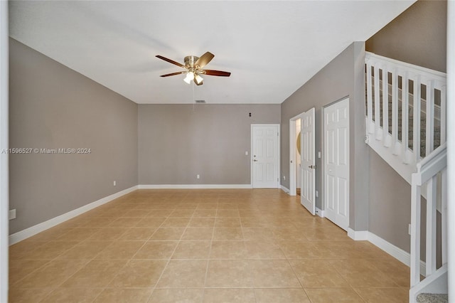 tiled empty room featuring ceiling fan