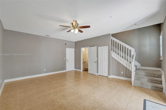 empty room with ceiling fan and light tile patterned flooring