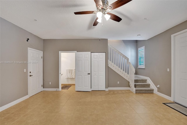 interior space with ceiling fan and light tile patterned flooring